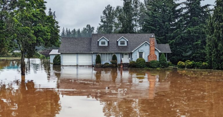a single-family home surrounded by flood waters