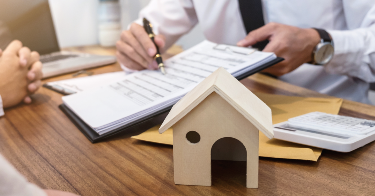 Businessman going over contract, house model