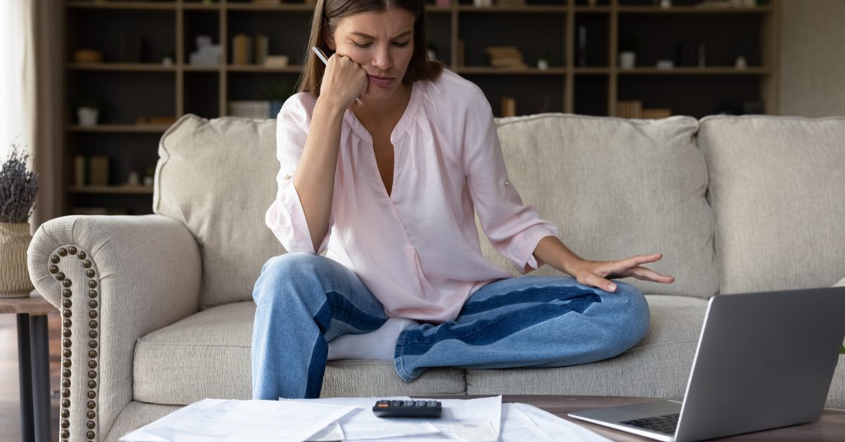 PEOPLE Frustrated woman doing calculations at home