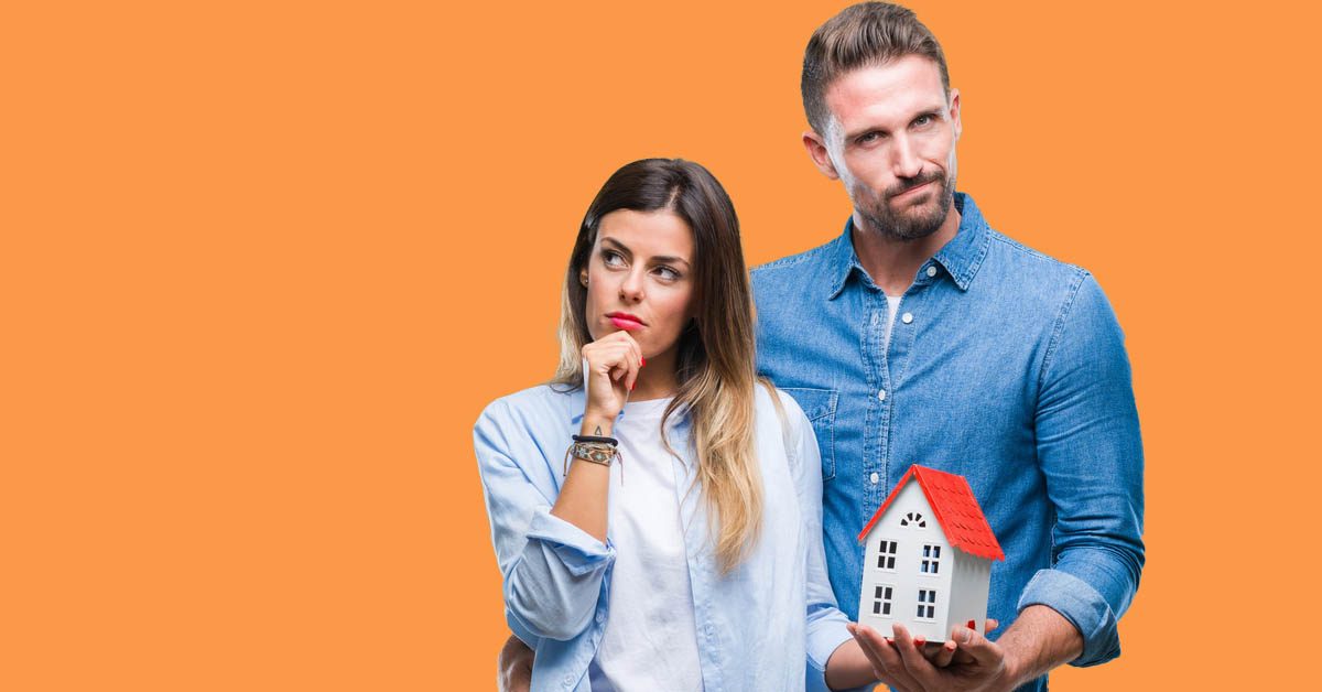 CONCEPT Orange couple holding house