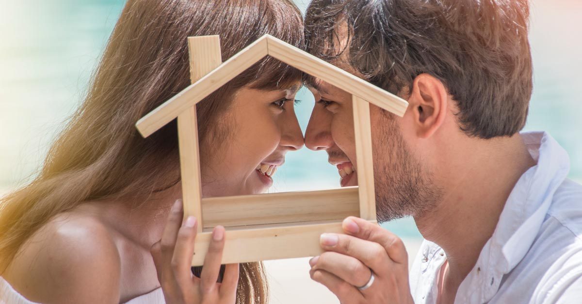 CONCEPT Young couple in love holding house together