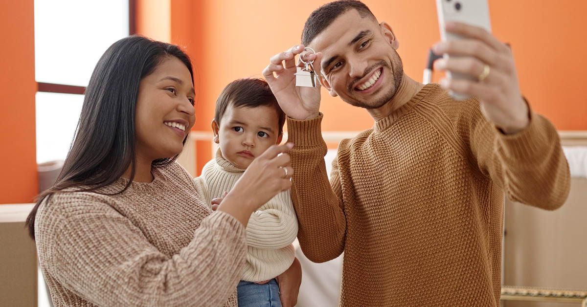 PEOPLE Family smartphone selfie holding keys at new home