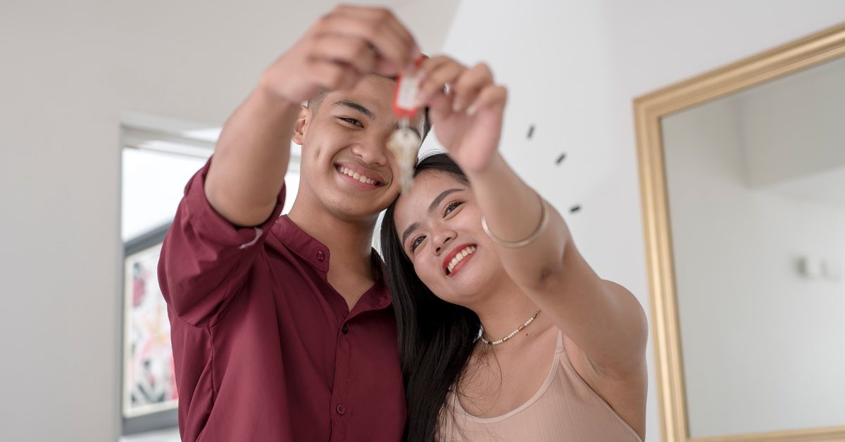 PEOPLE Happy young couple holds keys to new home
