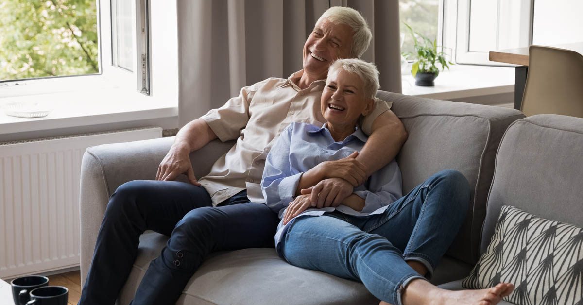 PEOPLE Joyful older couple relaxing on sofa