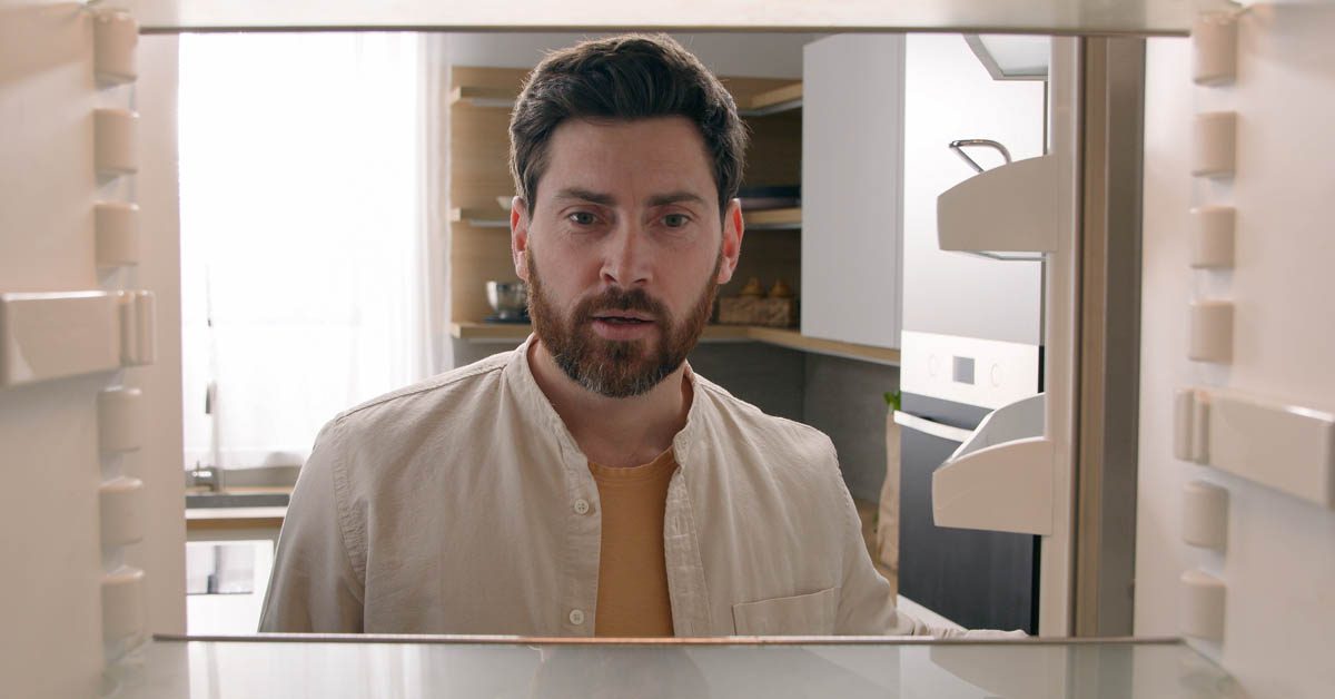 PEOPLE Man looking inside empty fridge