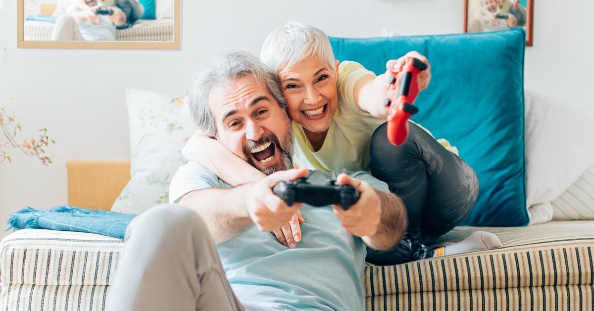 PEOPLE Senior couple playing video games at home