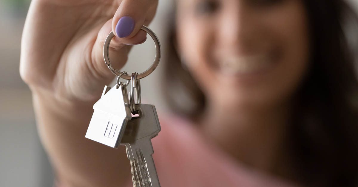 PEOPLE Single woman holding keys to house