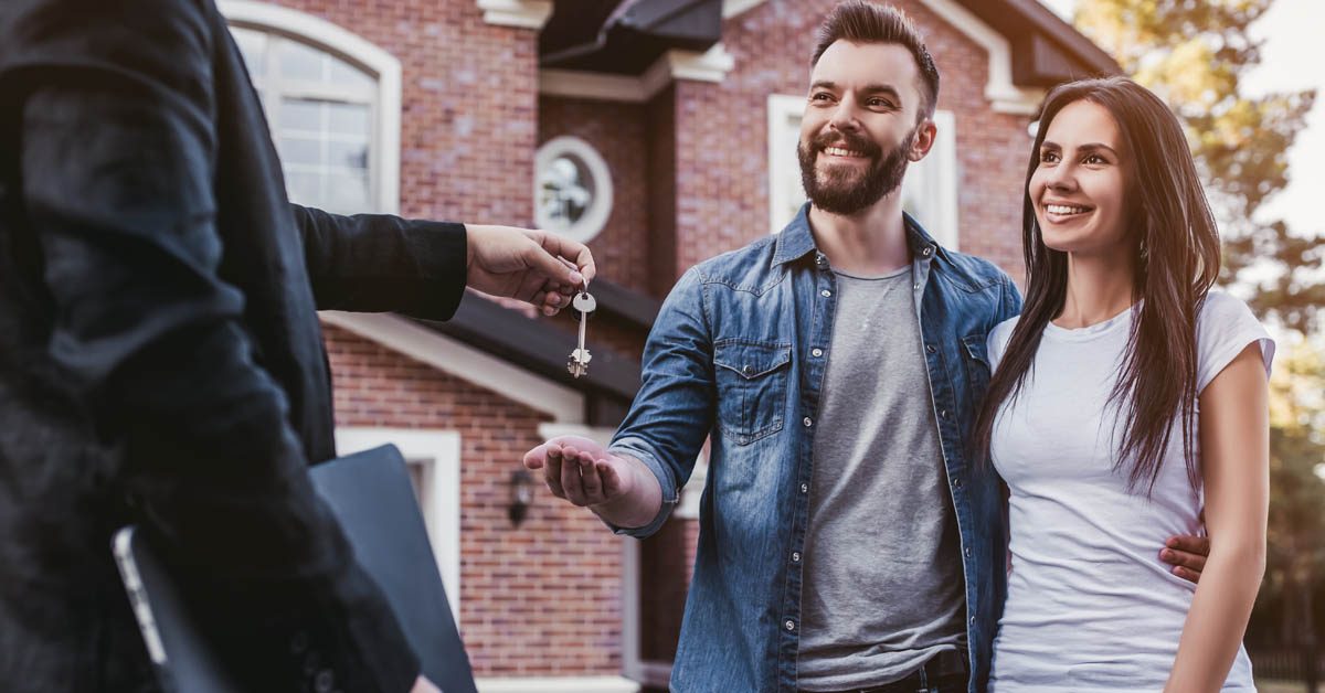 PEOPLE Millennial couple getting keys from agent