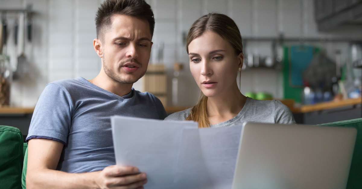 PEOPLE Confused couple looking at papers, laptop