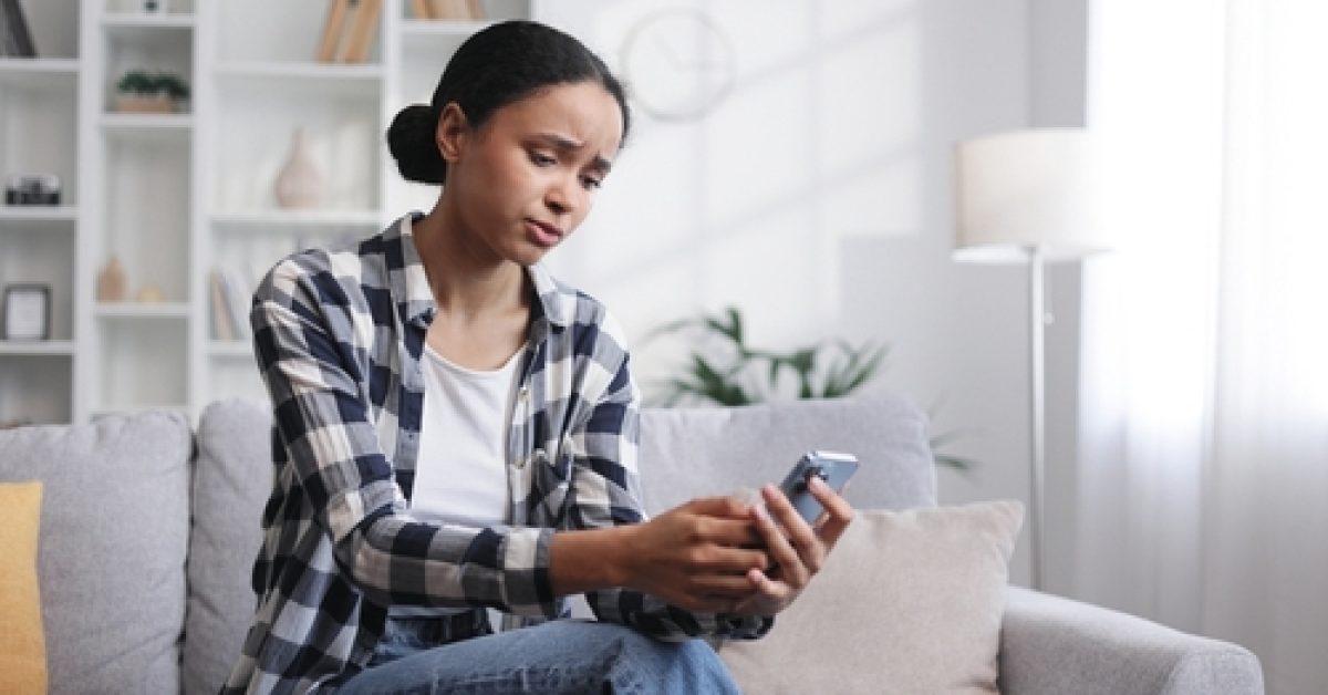 Worried,Young,African,American,Girl,Sitting,On,The,Sofa,Looking